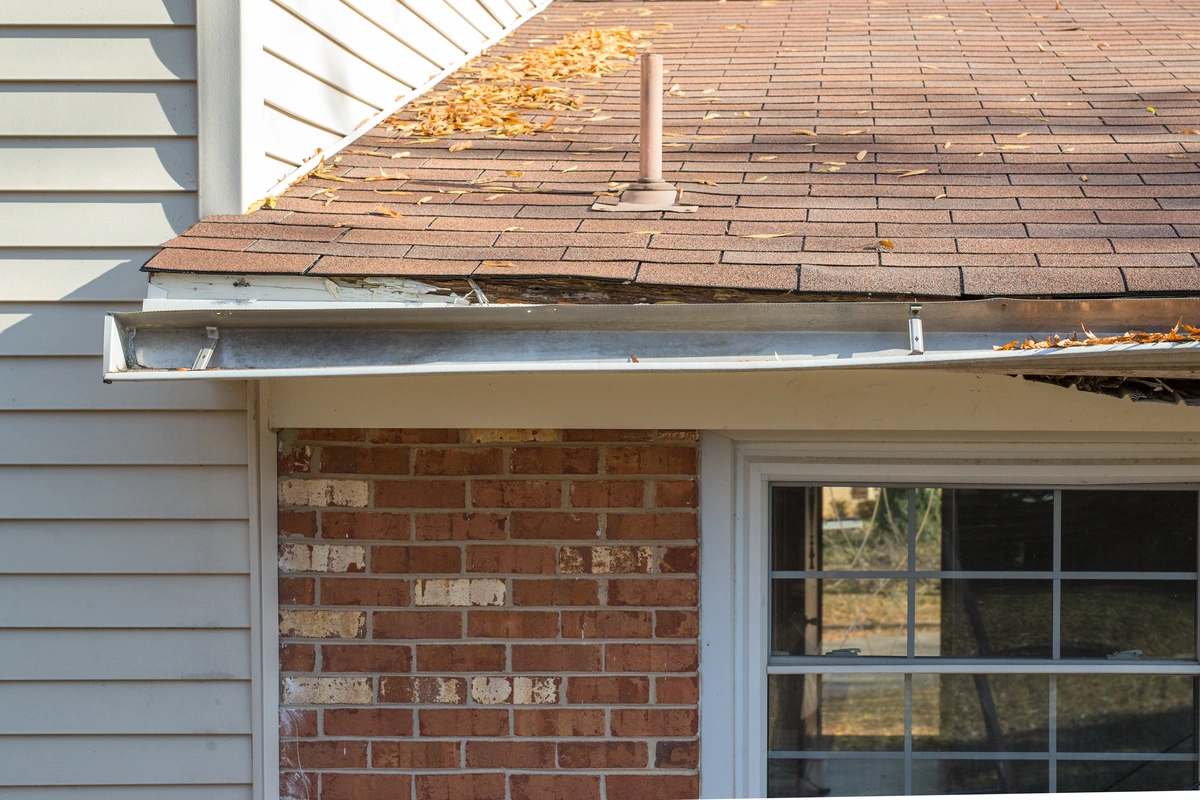 closeup of residential roof and gutters after storm damage