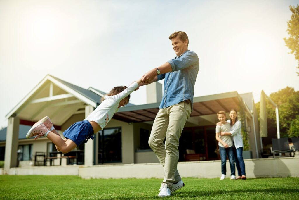 Outdoor, family and father swinging kid in home garden for bonding, connection and fun together. Happy, love and dad spinning and playing with girl child on weekend in backyard of house in summer
