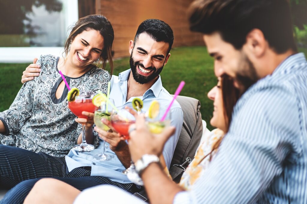 Cheerful group of friends having fun at backyard home