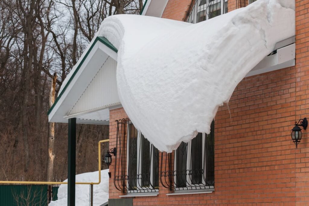 a dangerously large layer of snow on a roof