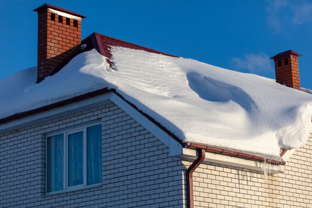 brick house with snow on the roof
