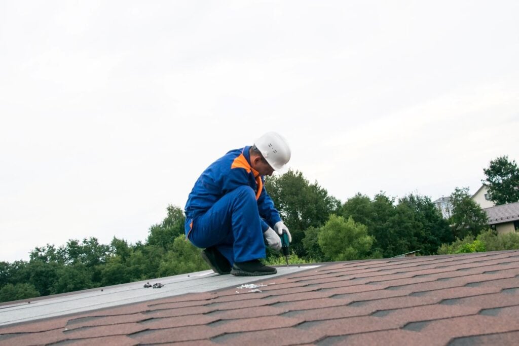 what causes roof leaks in chippewa falls wi homes worker repairing shingles
