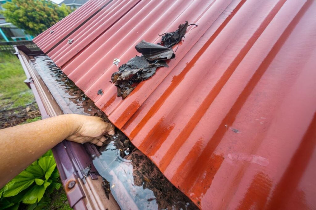 how long do roofs typically last in eau claire wi hand removing dirt and leaves from gutter